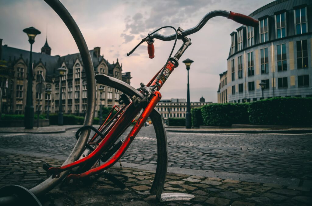 A dramatic shot of a broken bicycle in an urban cityscape setting in Liège, Belgium.
